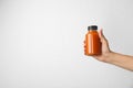 Woman holding bottle of carrot juice on grey background, closeup Royalty Free Stock Photo