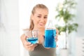 Woman holding bottle and glass with mouthwash Royalty Free Stock Photo