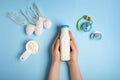 Woman holding bottle of milk with powder and toys on color background Royalty Free Stock Photo