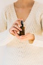 Woman holding a bottle with natural skincare product.