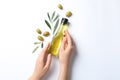 Woman holding bottle with oil and olives on white background Royalty Free Stock Photo