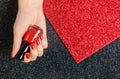 Woman holding bottle of red nail polish in manicured hand on color background. Space for text Royalty Free Stock Photo