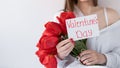 woman holding a bouquet of beautiful red tulips on a white background, Card with the inscription Valentine's Day. Royalty Free Stock Photo