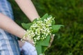 Woman holding a bouquet of lilly of valley flowers Royalty Free Stock Photo