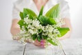 Woman holding bouquet of lily of the valley flowers Royalty Free Stock Photo