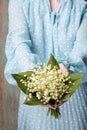 Woman holding bouquet of lily of the valley flowers Royalty Free Stock Photo