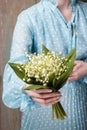 Woman holding bouquet of lily of the valley flowers Royalty Free Stock Photo