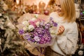 Woman holding a bouquet with pink, purple and white flowers wrapped in matte transparent paper Royalty Free Stock Photo