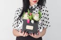 Woman holding bouquet of roses and tulips in box Royalty Free Stock Photo