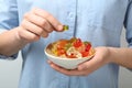 Woman holding bowl of colorful jelly bears on light background Royalty Free Stock Photo