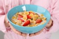 Woman holding bowl of crispy corn flakes with milk and strawberries, closeup Royalty Free Stock Photo