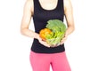 Woman holding bowl with fresh vegetables near the waist. Diet an