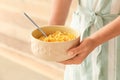 Woman holding bowl with healthy cornflakes, closeup