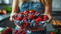 Woman holding a bowl of mixed berries including strawberries, raspberries Royalty Free Stock Photo