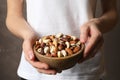 Woman holding bowl with organic mixed nuts Royalty Free Stock Photo