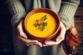 Woman holding bowl of pumpkin soup, closeup. Healthy food concept, Female hands holding a bowl of pumpkin soup, close-up view, AI Royalty Free Stock Photo