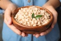 Woman holding bowl with shelled peanuts Royalty Free Stock Photo