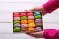 Woman holding box with colourful macaroons. Dessert. Summer travel vacation in French Riviera.