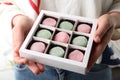 Woman holding box with different delicious mochi, closeup