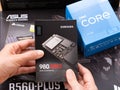 A woman holding a box with a Samsung SSD 980 PRO M2 over other boxes with brand new components in them for building a new PC.