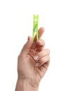 Woman holding bright green plastic clothespin on white background, closeup Royalty Free Stock Photo