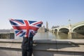 Woman holding British flag in front of face against Big Ben at London, England, UK Royalty Free Stock Photo