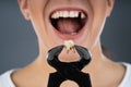 Woman Holding Broken Denture Using Pincers