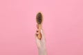 Woman holding brush with lost hair on pink, closeup. Alopecia problem Royalty Free Stock Photo