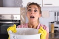 Woman Holding A Bucket While Water Droplets Leak From Ceiling
