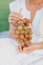 Woman holding bunch of fresh ripe juicy grapes on background of nature Royalty Free Stock Photo