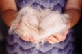 Woman holding a bunch of white cat fur after combing a Ragdoll cat with yellow brush/comb