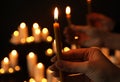 Woman holding burning candle in darkness against blurred background, Royalty Free Stock Photo