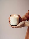 Woman holding burning candle, design and branding ready candle jar mockup with female hands, no face Royalty Free Stock Photo