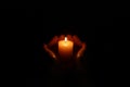 Woman holding burning candle in hands on black background, closeup Royalty Free Stock Photo