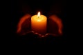 Woman holding burning candle in hands on black background, closeup Royalty Free Stock Photo