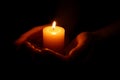 Woman holding burning candle in hands on black background, closeup Royalty Free Stock Photo