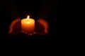 Woman holding burning candle in hands on black background, closeup. Space for text Royalty Free Stock Photo