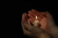 Woman holding burning candle in hands on black background, closeup. Space for text Royalty Free Stock Photo