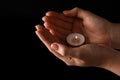 Woman holding burning candle in hands on black background, closeup. Space for text Royalty Free Stock Photo