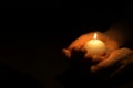 Woman holding burning candle in hands on black background, closeup. Space for text Royalty Free Stock Photo