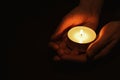 Woman holding burning candle in hands on black background, closeup. Space for text Royalty Free Stock Photo