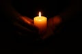 Woman holding burning candle in hands on black background, closeup Royalty Free Stock Photo