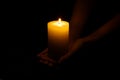 Woman holding burning candle in hands on black background, closeup Royalty Free Stock Photo