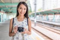 Woman holding camera in light rail station of Hong Kong Royalty Free Stock Photo