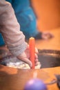 Woman holding a candle in hot wax, candle dipping