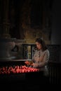 A girl is holding candle and praying near altar in church. Royalty Free Stock Photo