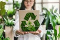 Woman Holding Cardboard Box With Green Recycle Symbol. Generative AI Royalty Free Stock Photo