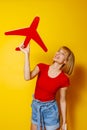 Woman holding cardboard plane on yellow background Royalty Free Stock Photo