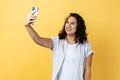 Woman holding cell phone making selfie or broadcasting livestream, expressing happiness. Royalty Free Stock Photo