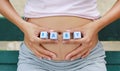 Woman holding character cubic `BABY` at her belly Royalty Free Stock Photo